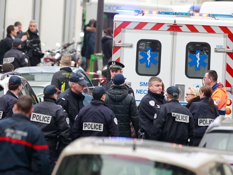 Police officers arrive at the scene after gunmen stormed a French newspaper, killing at least 12 peoplet, in Paris, France, Wednesday, Jan. 7, 2015.