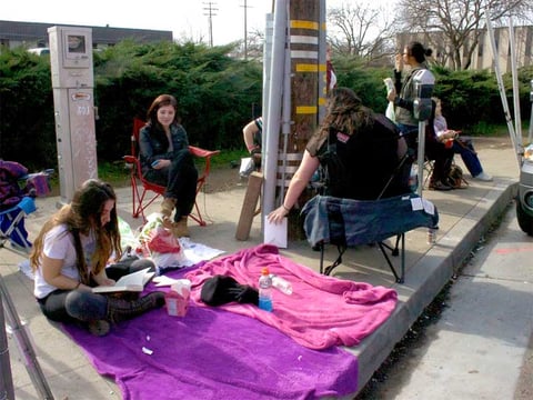 Amelia Zepeda from Chico reads a book on a blanket across from Ace Of Spades while waiting for a concert. She's been waiting since 6 a.m. and doors open at 7 p.m. 