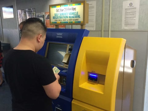 A man uses a self-service terminal to renew his registration at the Department of Motor Vehicles field office in Sacramento.