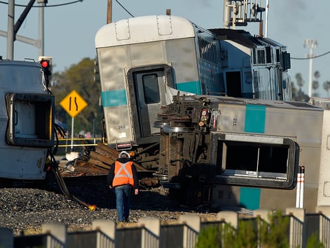 A worker walks along the tracks near the wreck of a Metrolink passenger train that derailed, Tuesday, Feb. 24, 2015, in Oxnard, Calif. 