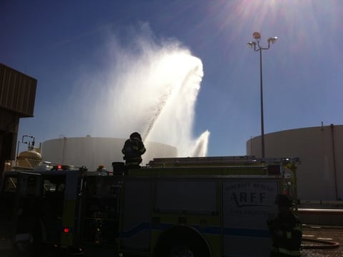 A Sacramento County Airport Fire Department tanker sprays water on a diesel container during Tuesday's drill.