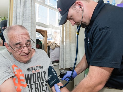 Paramedic Ryan Ramsdell checks 68-year-old Earl Mayes blood pressure during a home visit on March 26, 2015 in Sparks, Nevada. Ramsdell is part of a community health plan to help reduce avoidable emergency room visits by treating patients at home.