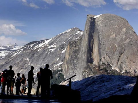 In this 2005 file photo, visitors view Half Dome from Glacier Point at Yosemite National Park. A massive sheet of rock has fallen from the vertical face of Half Dome, making one of the most popular routes attempted by climbers in North America. 