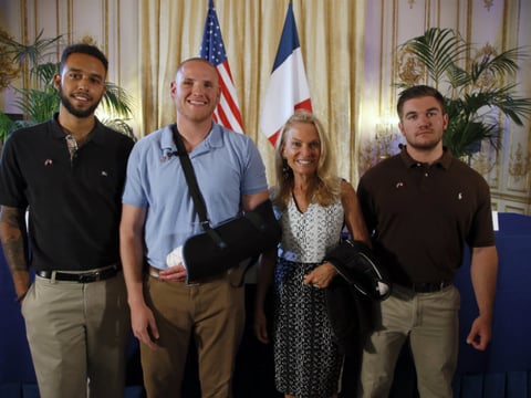 Anthony Sadler, left, U.S. National Guardsman Alek Skarlatos, right, and U.S. Airman Spencer Stone, second from left, pose for photographers with Jane D. Hartley, U.S. Ambassador to France, in Paris, France, Sunday, Aug. 23, 2015. 