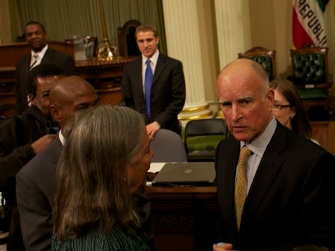 Calif. Gov. Jerry Brown chats with state lawmakers after his 2012 State of the State address.