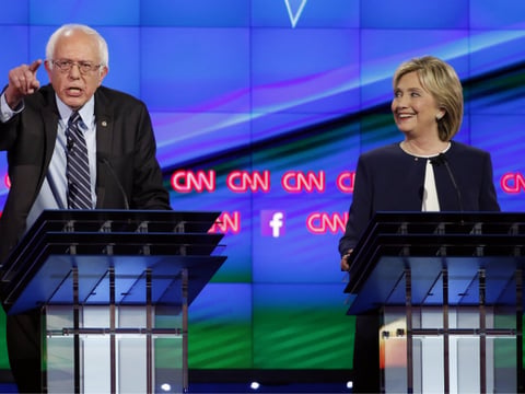 Sen. Bernie Sanders, of Vermont, left, speaks as Hillary Rodham Clinton looks on during the CNN Democratic presidential debate Tuesday, Oct. 13, 2015, in Las Vegas.