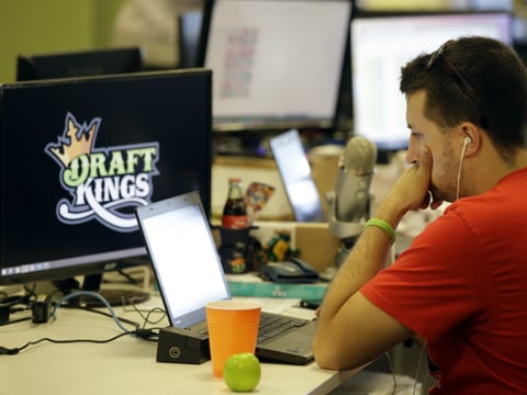 In this Sept. 9, 2015 file photo, Devlin D'Zmura, a tending news manager at DraftKings, a daily fantasy sports company, works on his laptop at the company's offices in Boston.