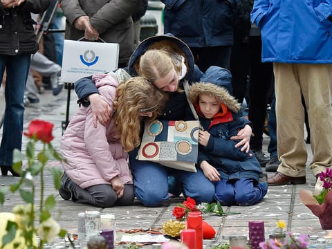 People mourn for the victims of the bombings at the Place de la Bourse, in the center of Brussels, on Wednesday.
