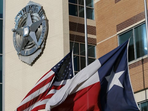 The American and Texas flag sit at half-staff outside of the Dallas police department headquarters, Friday, July 8, 2016, in Dallas
