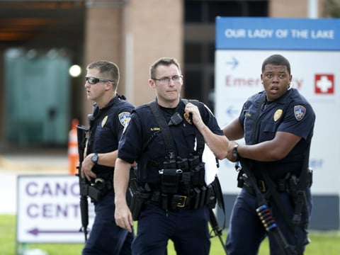 Police guard the emergency room entrance of Our Lady Of The Lake Medical Center, where wounded officers were brought, in Baton Rouge, La., Sunday, July 17, 2016.