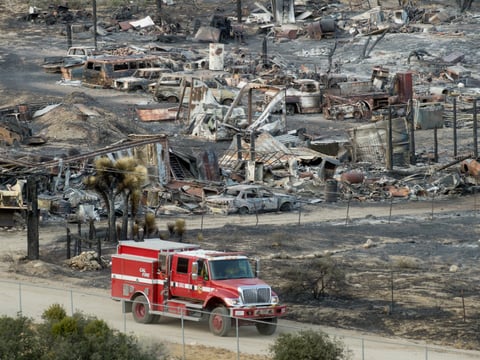 A firetruck passes scorched cars and trailers burned by the Blue Cut fire in Phelan, Calif., on Friday, Aug. 19, 2016. 