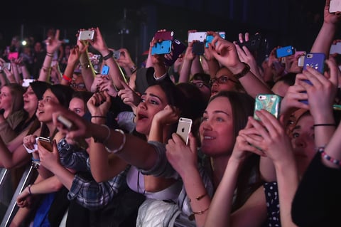 Concertgoers use their cellphones during a Fifth Harmony concert March 23, 2015, in New York. The company Yondr created a locking pouch to hold phones during performances, creating a "phone-free zone."