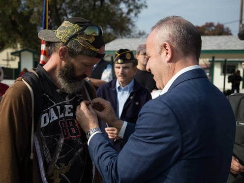Army veteran Richard Dean accepts an American flag pin from Mayor-elect Darrell Steinberg during a ceremony honoring Dean and other homeless veterans at Loaves and Fishes on Friday, Nov. 11.