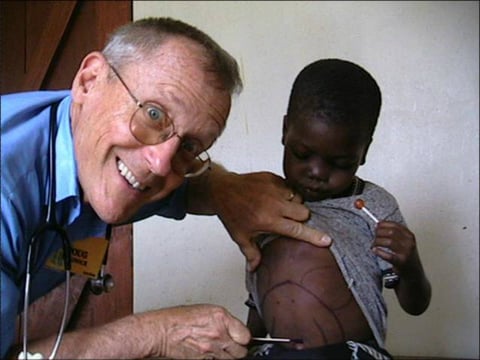 Dr. Doug caring for a young patient in an orphanage in Uganda in 2004.