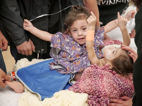 Conjoined twins Eva and Erika Sandoval say goodbye to their family before being taken to the operating room for separation in Palo Alto, Calif. 