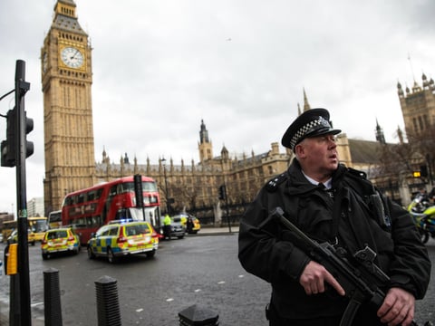 An armed police officer stands guard near Westminster Bridge and the Houses of Parliament on Wednesday in London, England.