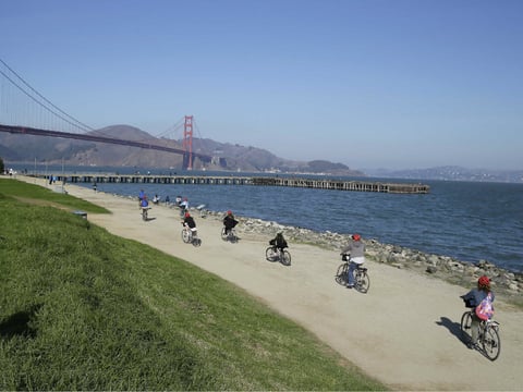 FILE - In this Nov. 25, 2014 file photo, a group of people on rental bicycles ride past Crissy Field toward the Golden Gate Bridge in San Francisco.
