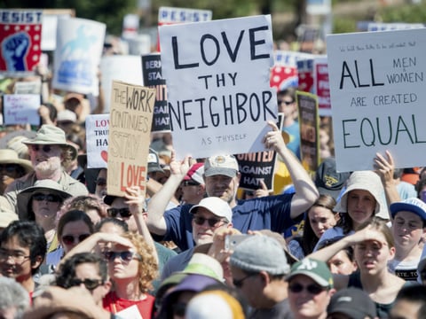 People hold up signs and shout while listening to speakers during a rally against hate in Berkeley, Calif., Sunday, Aug. 27, 2017.