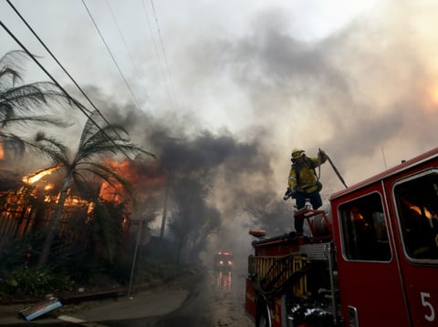 A Los Angeles County firefighter prepares to battle a hot spot on the "Creek Fire" in the Lake View Terrace area of Los Angeles, Tuesday, Dec. 5, 2017. 