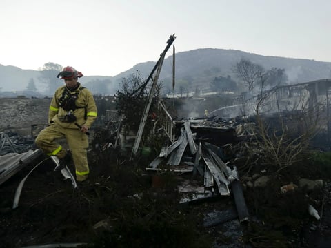 Fire crews search for hot spots among destroyed homes in the Rancho Monserate Country Club community Friday, Dec. 8, 2017, in Fallbrook, Calif.