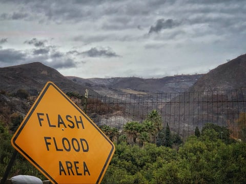 In this photo provided by Santa Barbara County Fire Department, a flash flood area sign is posted, as evacuations have been issued for several fire-ravaged communities in Santa Barbara, Calif., Monday, Jan. 8, 2018.