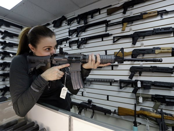 Gun shop owner Tiffany Teasdale-Causer points a Ruger AR-15 semi-automatic rifle, the same model, though in gray rather than black, used by the shooter in a Texas church massacre two days earlier, as she talks about the gun, Tuesday, Nov. 7, 2017.