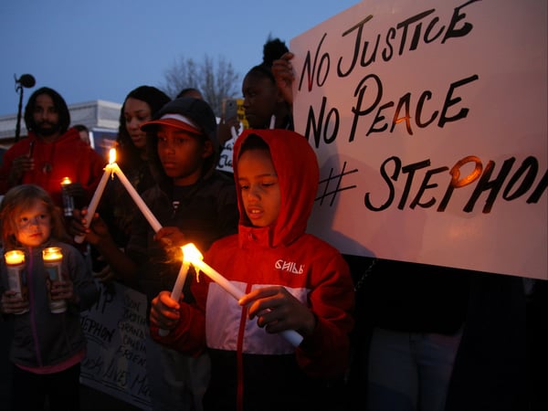 Children light candles at a vigil for Stephon Clark in South Sacramento in March 2018.