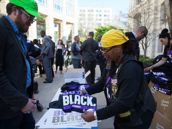 Activists hand out Build. Black. shirts in front of City Hall before a community forum on the shooting of Stephon Clark March 27, 2018.