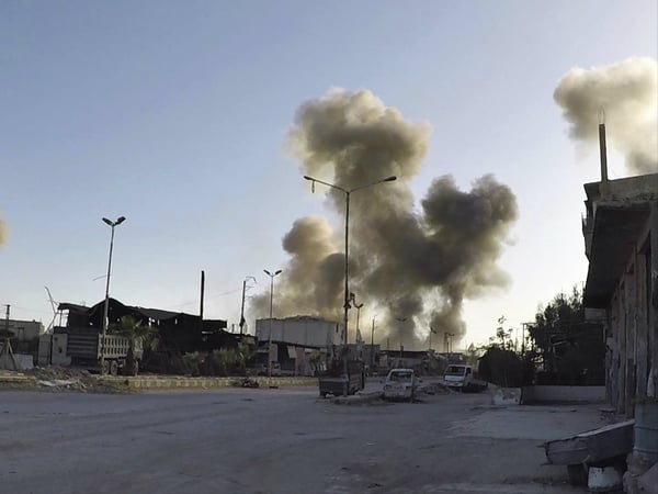 This photo released by the Syrian Civil Defense White Helmets, which has been authenticated based on its contents and other AP reporting, shows smoke rising after Syrian government airstrikes hit in the town of Douma.