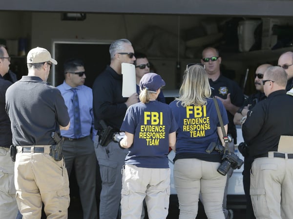 Authorities huddle outside a home searched in connection with the arrest of a man on suspicion of murder, Wednesday, April 25, 2018, in Citrus Heights, Calif. 