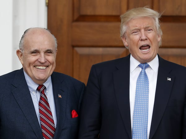 In this Nov. 20, 2016, file photo, then-President-elect Donald Trump calls out to media as he and former New York Mayor Rudy Giuliani pose for photographs as Giuliani arrives at the Trump National Golf Club Bedminster clubhouse in Bedminster, N.J..