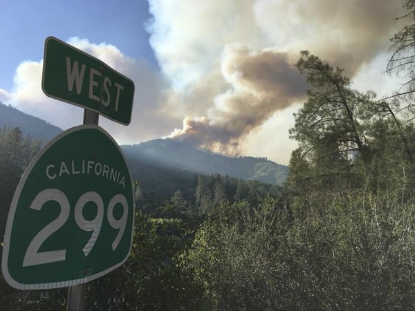 In this Wednesday, July 25, 2018 photo provided by the California Highway Patrol, the Carr Fire burns near Highway 299 and Redding, Calif. The fire is one of several across California amid a heat wave that has seen days of triple-digit temperatures.