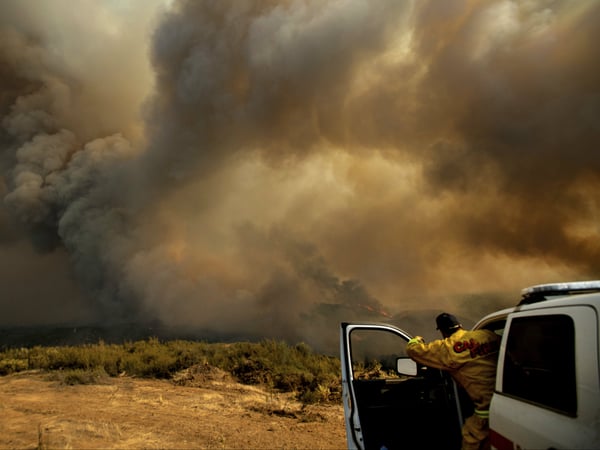 Cal Fire Division Chief Mark Higgins directs helicopters dropping water as the River Fire burns in Lakeport, Calif., Tuesday, July 31, 2018. 