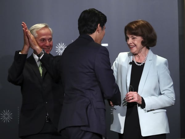 Public Policy Institute of California CEO and debate monitor Mark Baldassare, left, applauds as California Sen. Kevin de Leon, D-Los Angeles, embraces California Sen. Dianne Feinstein, D-Calif., at the end of the debate on Wednesday, Oct. 17, 2018.