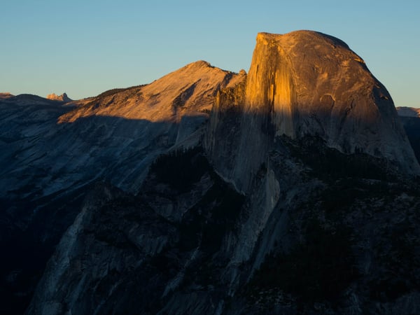 The sun sets over Half Dome in Yosemite National Park.
