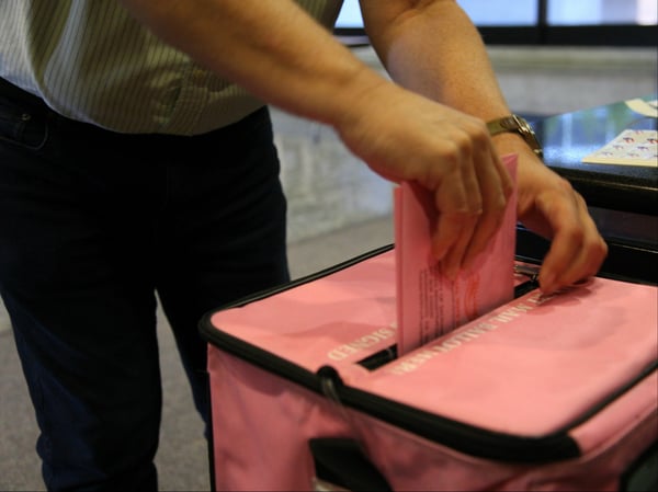 A voter turns in a mail-in ballot, Nov. 6, 2018.