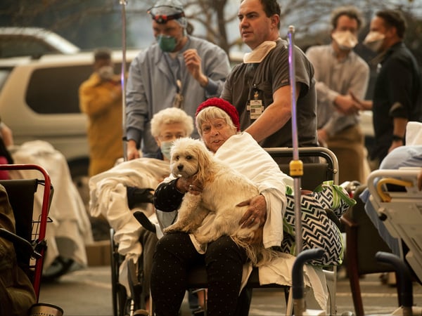 Medical personnel evacuate patients as the Feather River Hospital burns while the Camp Fire rages through Paradise, Calif., on Thursday, Nov. 8, 2018. Tens of thousands of people fled a fast-moving wildfire Thursday in Northern California.
