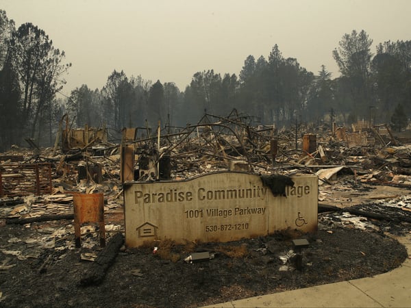 A sign stands at a community destroyed by the Camp fire, Tuesday, Nov. 13, 2018, in Paradise, Calif.