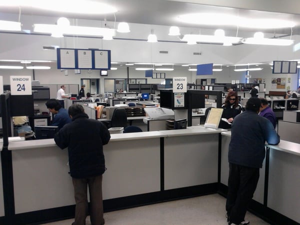 People wait at counters at the DMV in Fullerton, Calif.