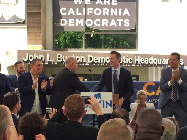California Gov. Jerry Brown shakes hands with Lt. Gov. Gavin Newsom after endorsing Newsom to succeed him at a California Democratic Party unity event on June 13, 2018.