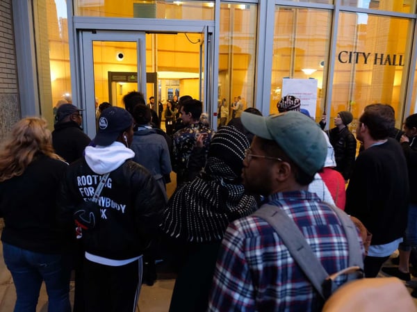 People wait to get numbers for seating at Tuesday's City Council meeting.