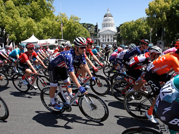 The peloton passes the California state Capitol as the riders go into a turn during the first stage of Amgen Tour of California cycling race Sunday, May 12, 2019, in Sacramento.