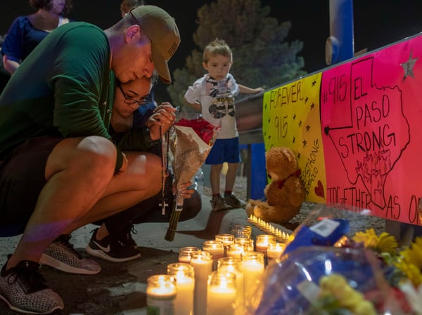 Rene Aguilar and Jackie Flores pray at a makeshift memorial for the victims of Saturday's mass shooting at a shopping complex in El Paso, Texas, Sunday, Aug. 4, 2019.