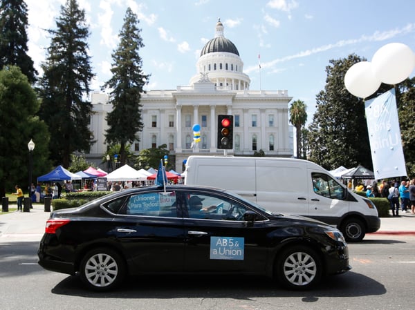 Dozens of supporters of a measure to limit when companies can label workers as independent contractors circle the Capitol during a rally in Sacramento, Calif., Wednesday, Aug. 28, 2019.