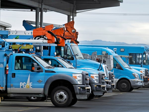 This Jan. 14, 2019, file photo shows Pacific Gas & Electric vehicles parked at the PG&E Oakland Service Center in Oakland, Calif.
