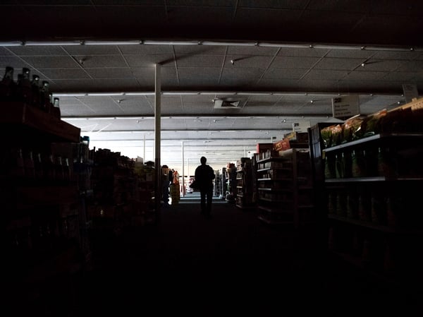 Shift supervisor James Quinn walks through a darkened CVS Pharmacy as downtown Sonoma, Calif., remains without power on Wednesday, Oct. 9, 2019.