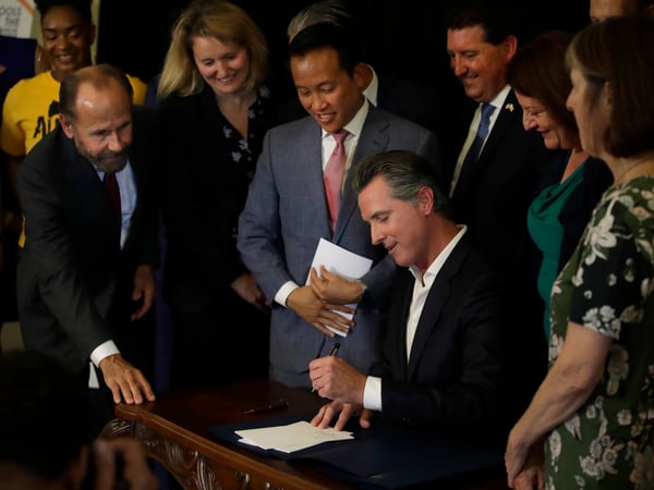 California Gov. Gavin Newsom signs bill AB 1482, Tuesday, Oct. 8, 2019, in Oakland, Calif. AB 1482 will cap rent increases at 5% each year plus inflation. The bill will also ban landlords from evicting tenants without just cause.