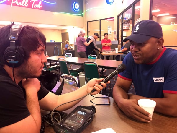 NextGen student Ricardo Tovar, left, interviews Nigerian immigrant Victor Igbinedion during a bingo night in Meadowview.