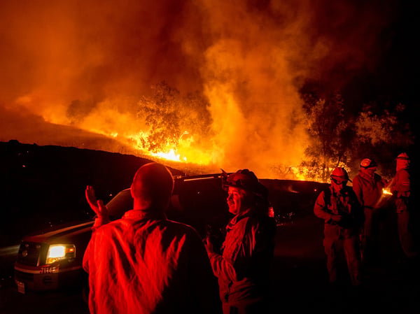 Firefighters confer while battling the Kincade Fire near Geyserville, Calif., on Thursday, Oct. 24, 2019.