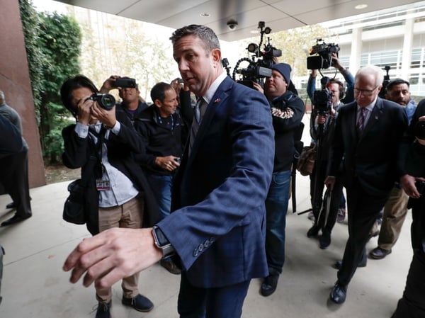 California Republican Rep. Duncan Hunter reaches to open the door to federal court Tuesday, Dec. 3, 2019, in San Diego.